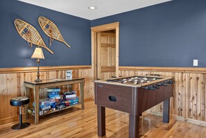A room with a foosball table, wooden paneling, and a table with board games. - Ski-out to Hatley Pointe Hot Tub Sleeps 8 (Mars Hill)