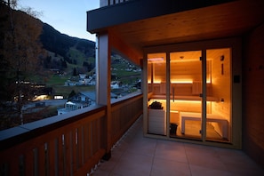 A wooden balcony with a view of a hillside village. - Penthouse Suite With Outdoor Sauna (Gaschurn)