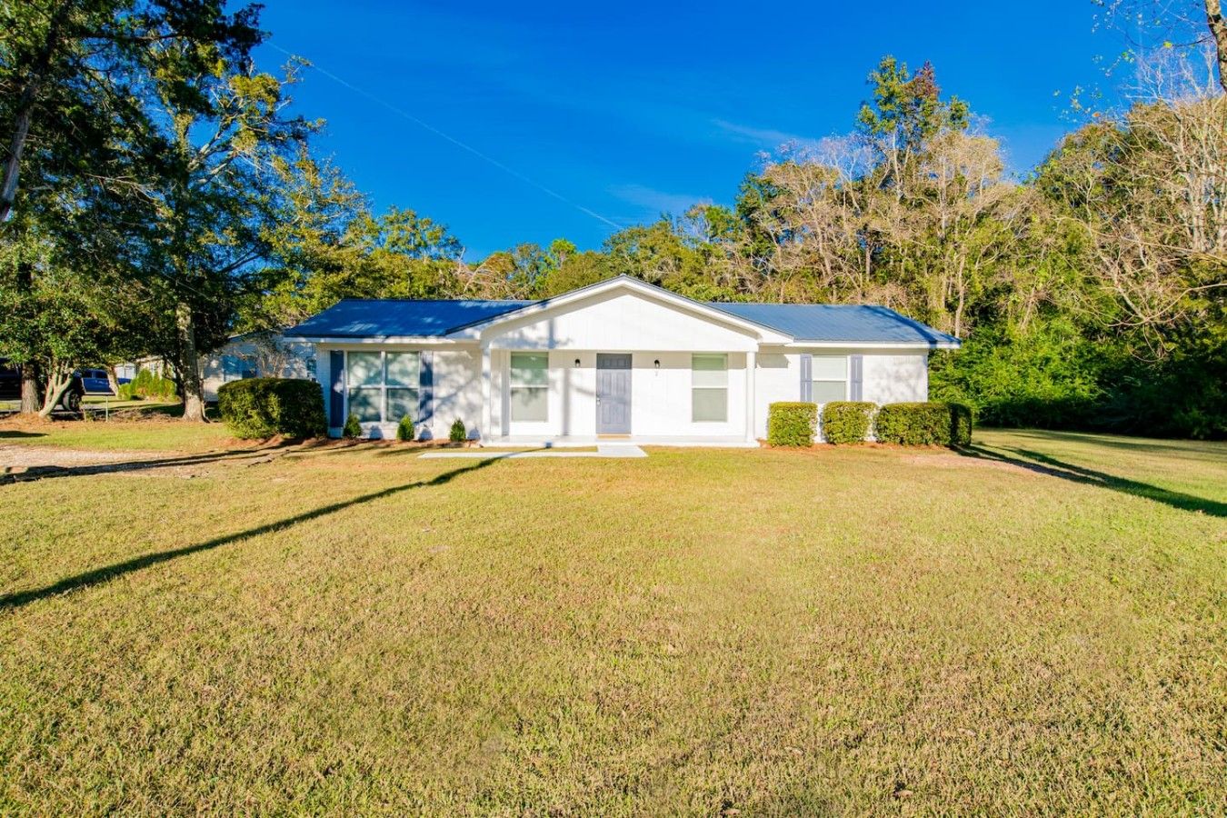 A single-story house with a front porch, a garage, and a well-maintained lawn.