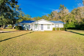 A single-story house with a front porch, a garage, and a well-maintained lawn. - South Alabama Home near Colleges (Mobile)