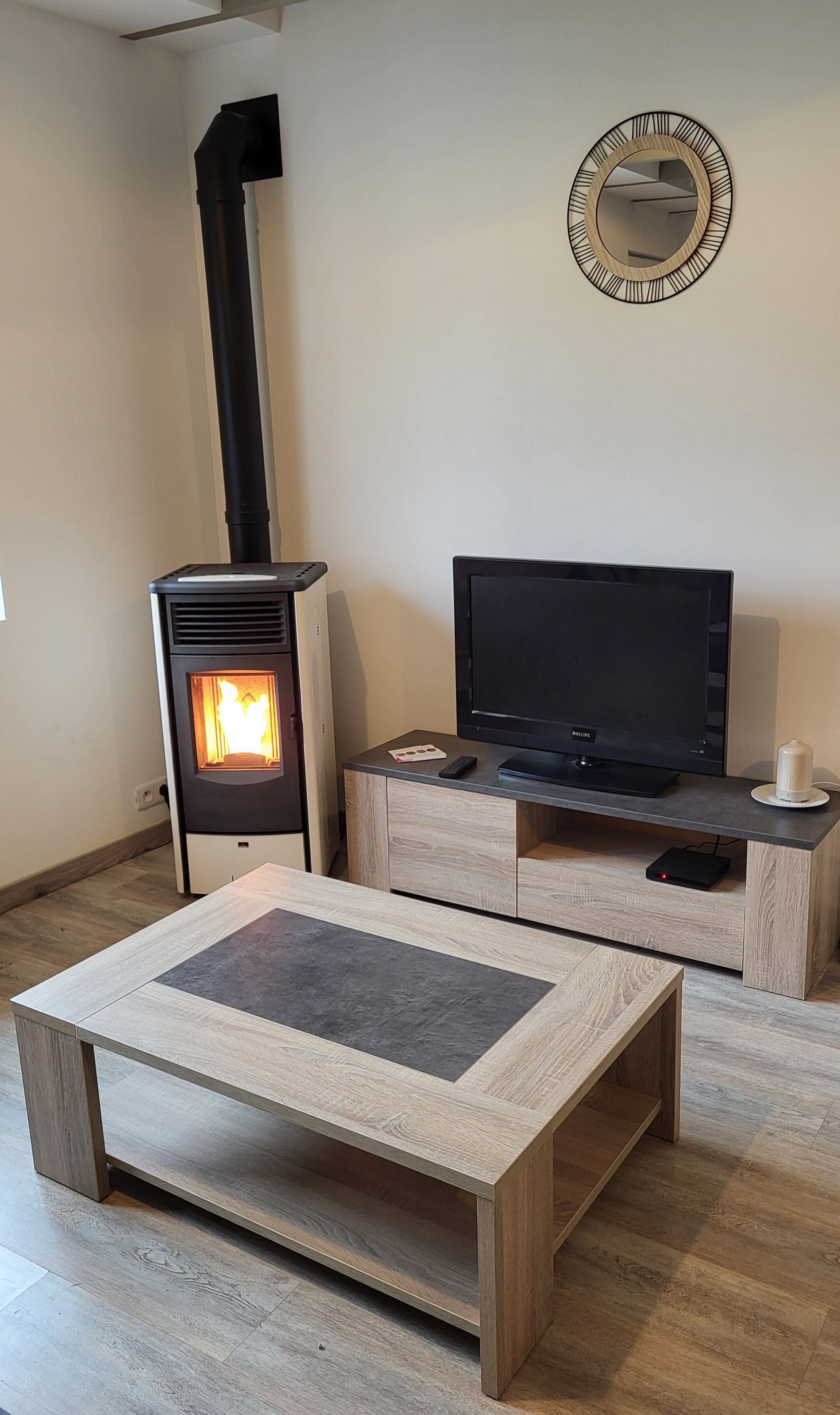 Un salon équipé d’un poêle à bois, d’un téléviseur à écran plat et d’une table basse.