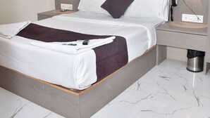 Una camera da letto moderna con un letto grande, due comodini, un piano di appoggio e una lampada a parete.