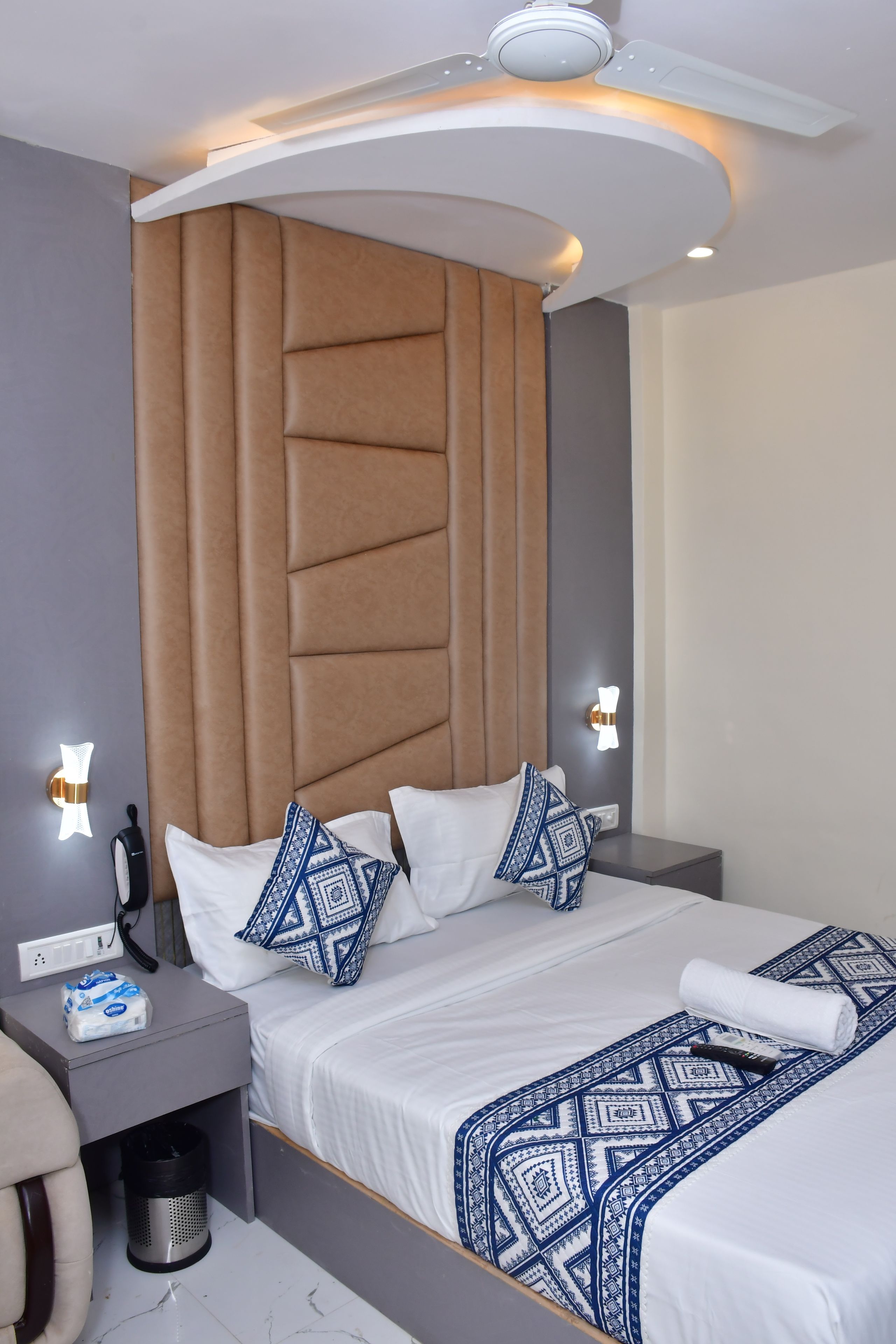 Una habitación de hotel moderna con una cama grande, mesitas de noche, un escritorio y un baño.