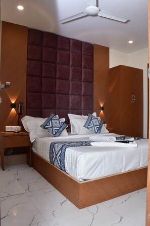 A hotel room with a bed, nightstands, a wardrobe, and a ceiling fan.