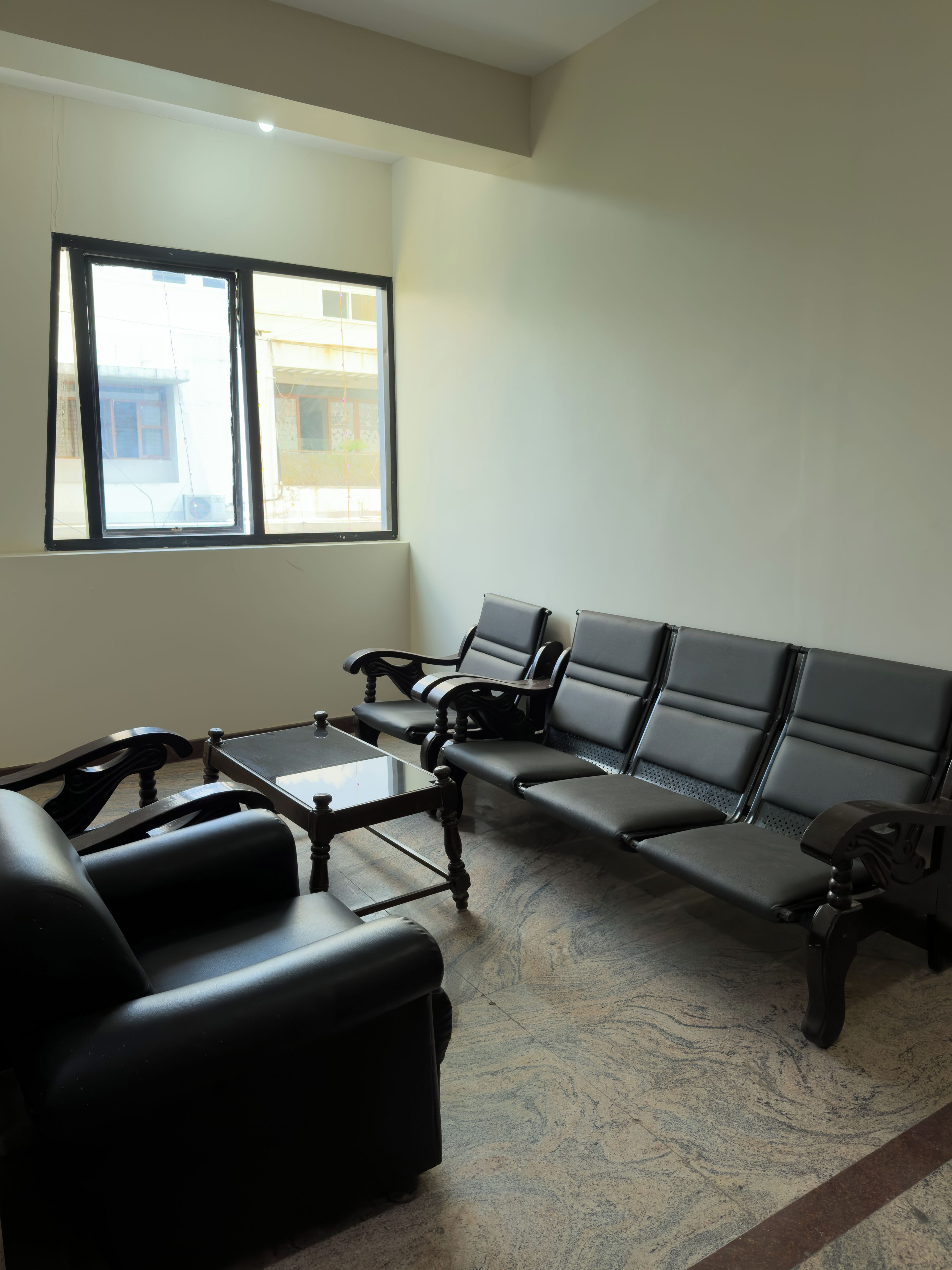 A waiting area with a sofa, a table, and a row of chairs.