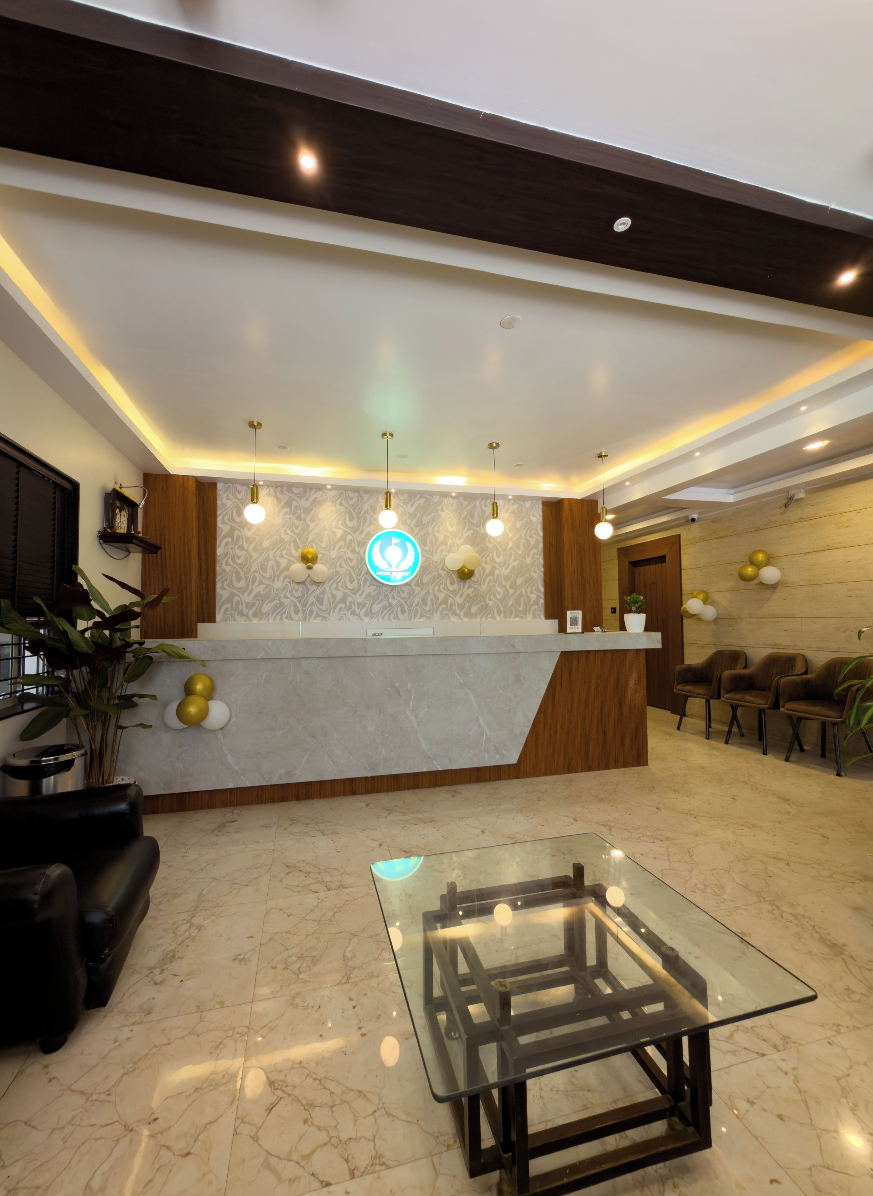 A reception area with a marble floor, a glass-top table, and a reception desk with a wooden finish.