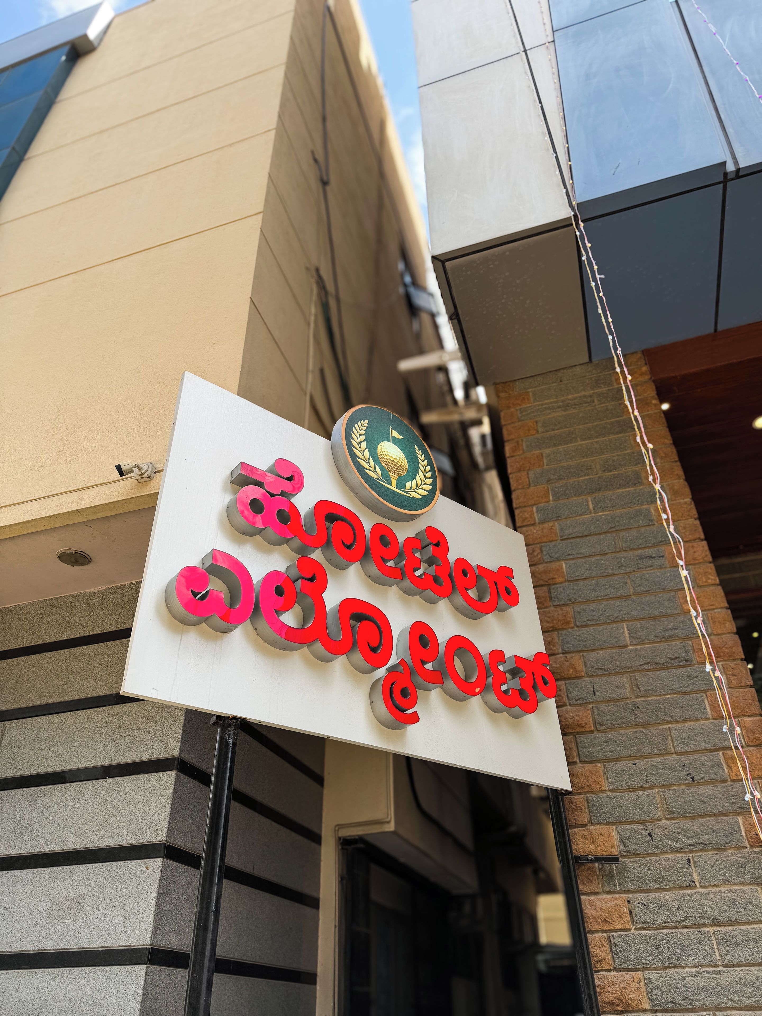 A sign with a golf ball and laurel wreath emblem, indicating a golf-related establishment.