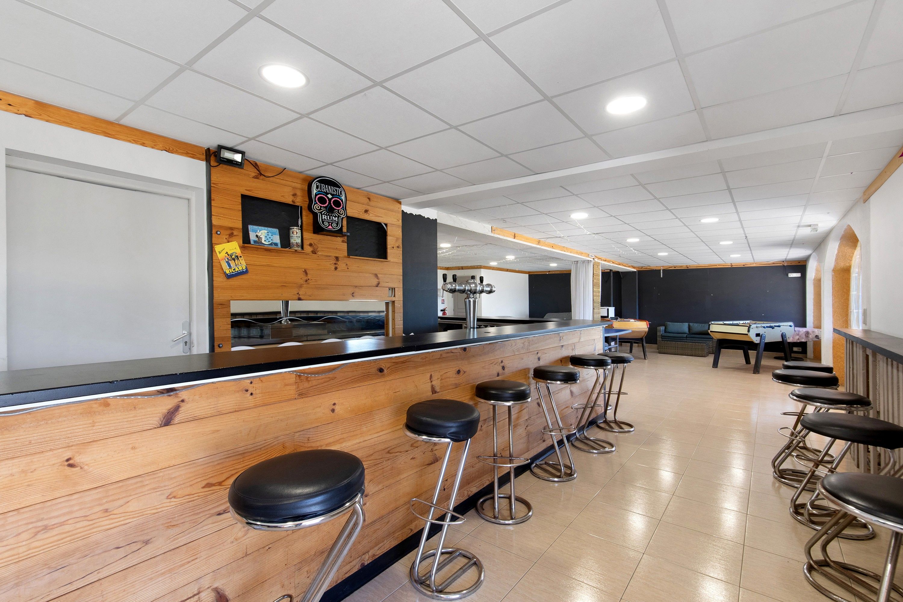 Un espace bar avec des tabourets et un comptoir en bois.