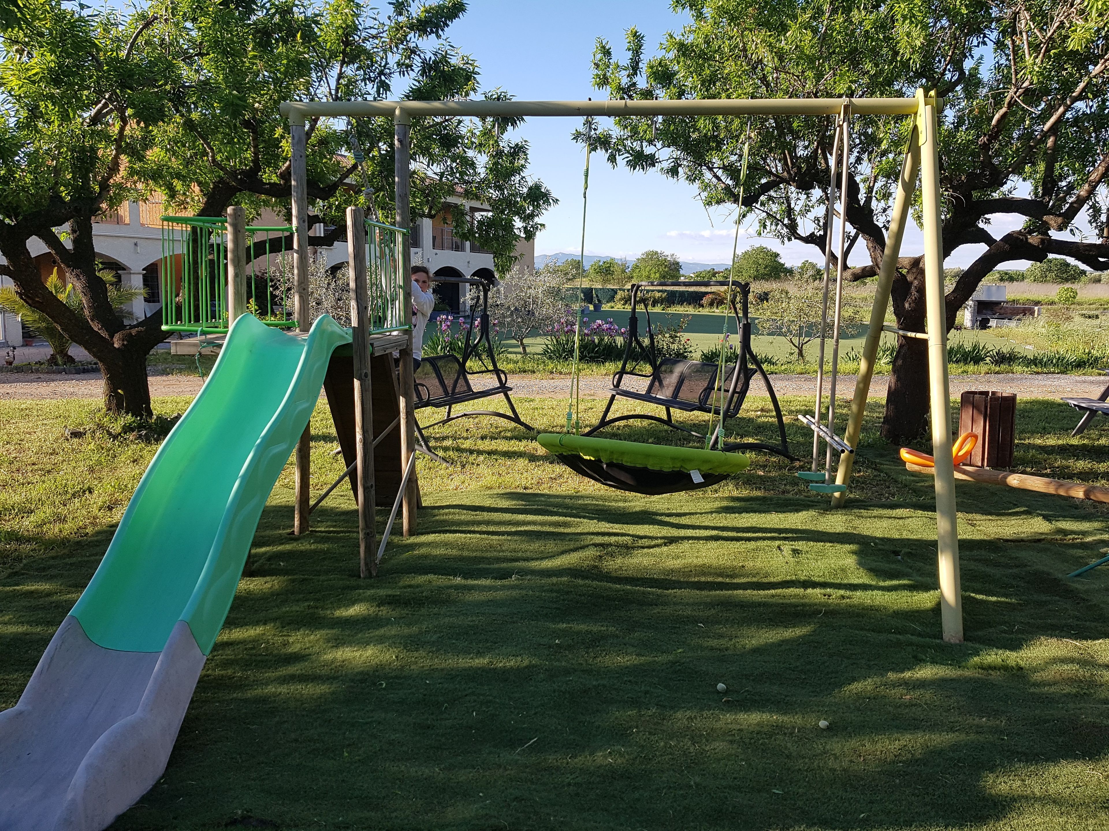 A playground with a slide, swings, and a swing set.