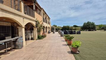 A courtyard with outdoor seating, a wooden table, and potted plants.