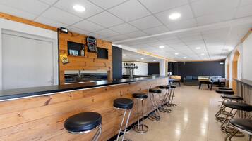 A bar area with wooden bar stools and a counter.