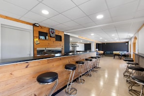 A bar area with wooden bar stools and a counter.