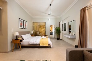 A hotel room with a bed, bedside table, lamp, potted plant, and a mirror. - Luxury stay at Degla by Spacey #68 (Cairo)