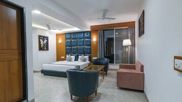 A modern hotel room with a bed, seating area, and a large window.