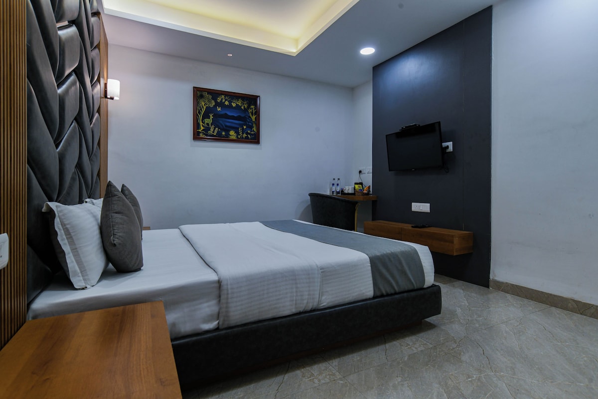 A modern bedroom with a bed, bedside table, and a mounted TV.