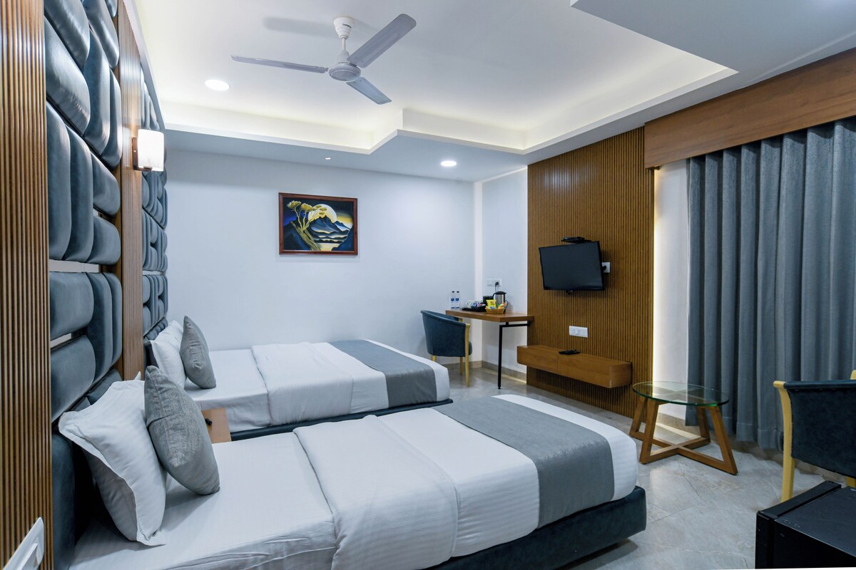 Una habitación de hotel moderna con una cama, un escritorio, un televisor y un cuadro en la pared.