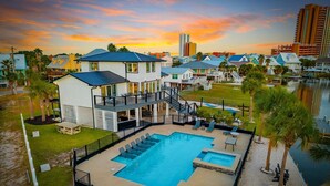 Ein Resort mit Schwimmbad, Sitzgelegenheiten im Freien und Blick auf das Wasser.