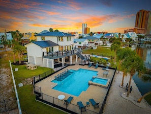 A resort with a swimming pool, outdoor seating, and a view of the water. - Boat-Friendly Waterfront Luxury Home in Gulf Shores | Sleeps 19 (Gulf Shores)