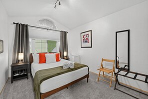 A hotel room with a bed, a chair, a mirror, a window, and a picture on the wall. - Pnw Home With Sundance Hot Tub 3 Bedroom Home (Bonney Lake)