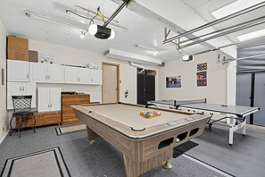 A pool table with a billiard cue and balls, a ping pong table, and a cabinet with a ladder. - Pnw Home With Sundance Hot Tub 3 Bedroom Home (Bonney Lake)