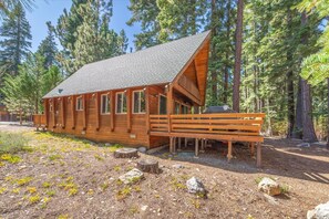 A wooden cabin with a sloped roof, a deck, and a natural forest setting. - Tahoma Family Cabin 3 Bedroom Home (Homewood)