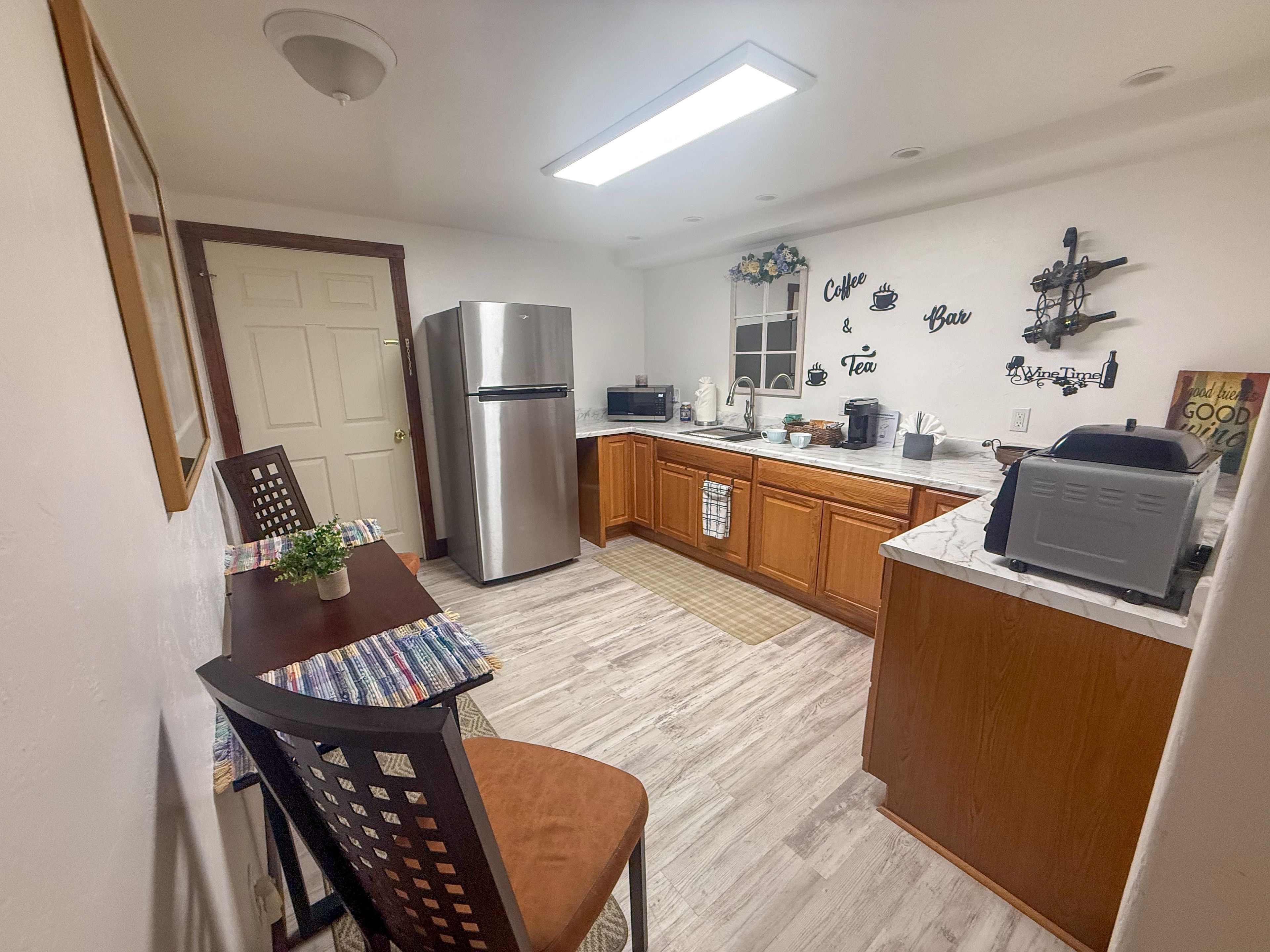 A compact kitchen with a refrigerator, microwave, and coffee maker.
