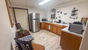 A compact kitchen with a refrigerator, microwave, and coffee maker.