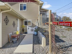A residential property with a covered porch, a fenced yard, and a sign reading 'GUEST Quarters.' - Forever Family Farm 3 Bedroom Home (Montrose)