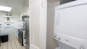 Cuina compacta amb nevera, microones, forn i rentadora.