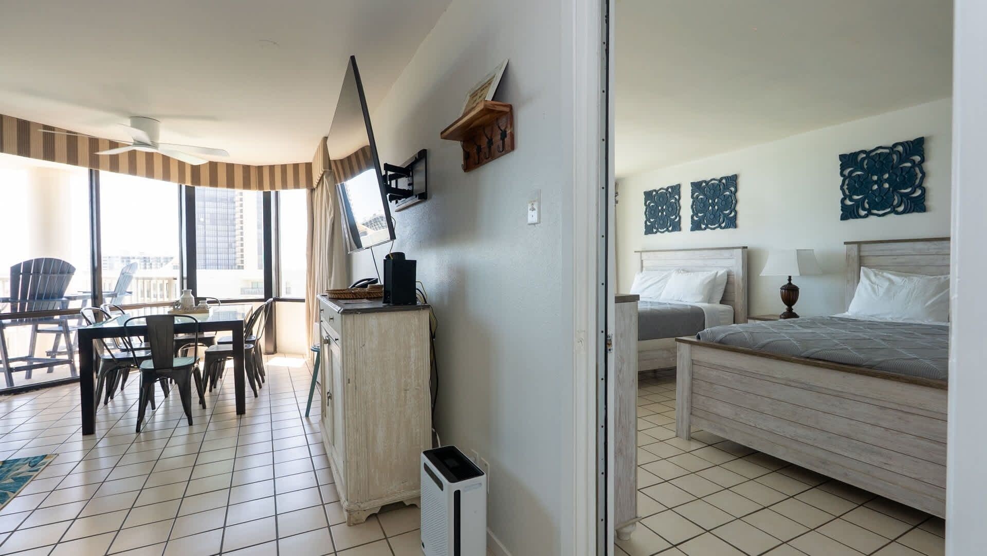 Quarto de hotel com cama, mesa de cabeceira e escrivaninha com cadeira.