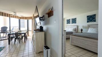 Quarto de hotel com cama, mesa de cabeceira e escrivaninha com cadeira.