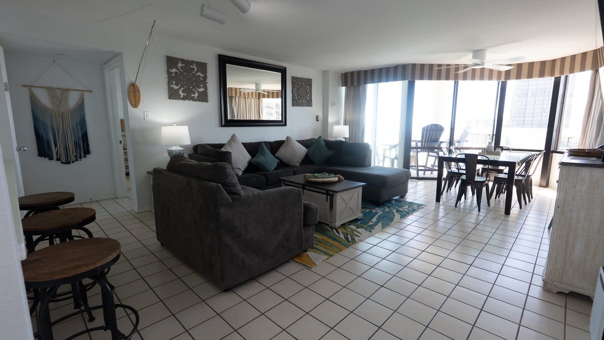 A living room with a sofa, coffee table, and dining area with chairs.