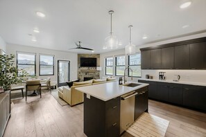 A modern kitchen with a central island, dark cabinetry, and a large window. - Shangri-la 102 3 Bedroom Apts (Heber City)