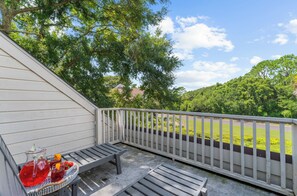 A balcony with a view of a green landscape and a road. - Sunny, charming home short walk to beach (Seabrook Island)