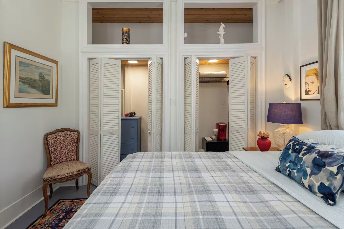 A bedroom with a bed, a chair, a dresser, and a nightstand.