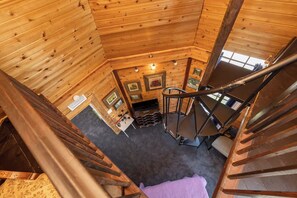A wooden interior with a staircase leading to a lower level. - The Tower | Historic Tower Retreat at The Old Spanish Consulate (Pensacola)