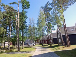 A residential area with houses, a paved pathway, and trees. - Vacation home with a fireplace and infrared sauna, about 800 meters from the sandy beach, washing machine (Glowe)
