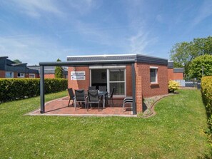 A brick building with a covered patio area, a sign indicating 'HOOGE HORN,' and a grassy lawn. - Holiday Home With 2 Bedrooms (Esens)
