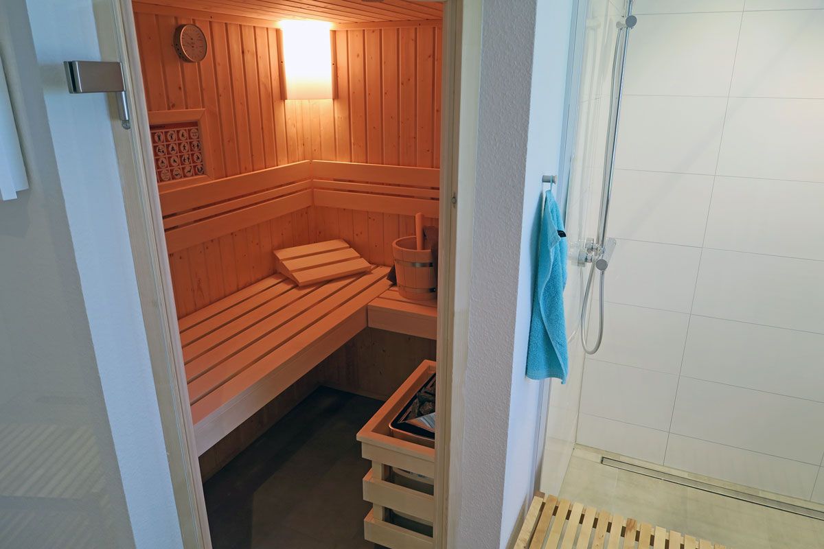 Un sauna avec des bancs en bois et un appareil de chauffage visible.