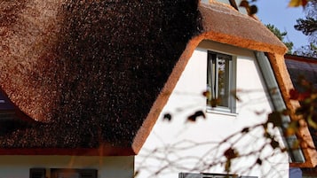 Ein traditionelles Haus mit einem steilen Dach und einem kleinen Fenster.