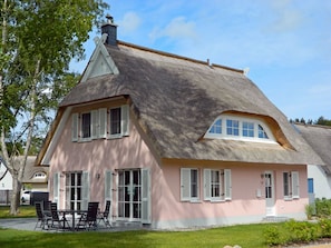 A house with a steeply pitched roof, white shutters, and a visible chimney. - Vacation home with a fireplace and sauna, about 450 meters from the sandy beach, washing machine, dryer (Glowe)