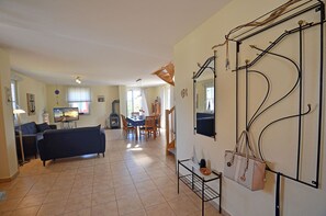 A spacious living area with a sofa, TV, and a fireplace. - Vacation home with a fireplace, about 400 meters from the sandy beach, with a washing machine and Wi-Fi (Glowe)