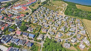 An aerial view of a residential area with houses, roads, and a body of water. - Vacation home with a fireplace, about 400 meters from the sandy beach, with a washing machine and Wi-Fi (Glowe)