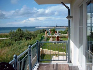 Un balcon avec vue sur la mer et une statue.