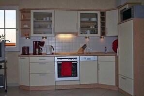 A kitchen with a dishwasher, oven, and cabinets. - Right on the sandy Baltic Sea beach with a view of the sea!, Wi-Fi, washing machine, accommodates up to 3 people (Glowe)