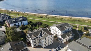 A coastal residential area with multiple two-story houses, a beach, and a promenade. - Just 50 meters from the sandy Baltic Sea beach, Wi-Fi, accommodates up to 4 people, with a covered patio (Glowe)