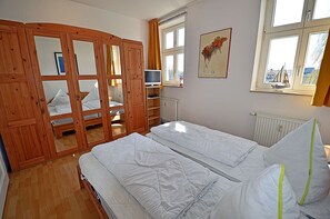 Makuuhuone, jossa on sänky, vaatekaappi, patteri ja ikkuna, josta on näkymä.