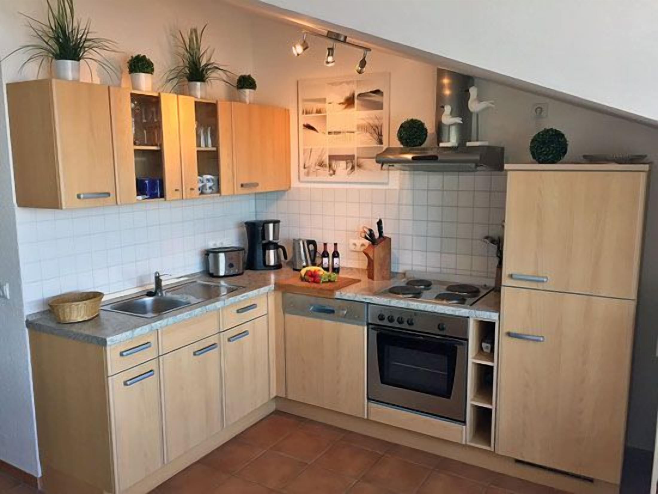 A kitchen with wooden cabinets, a stove, a sink, and a dishwasher.