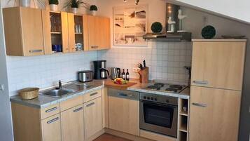 A kitchen with wooden cabinets, a stove, a sink, and a dishwasher.