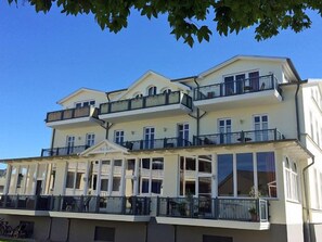 Ein mehrstöckiges Hotel mit Balkonen, großen Fenstern und einem klassischen Baustil.